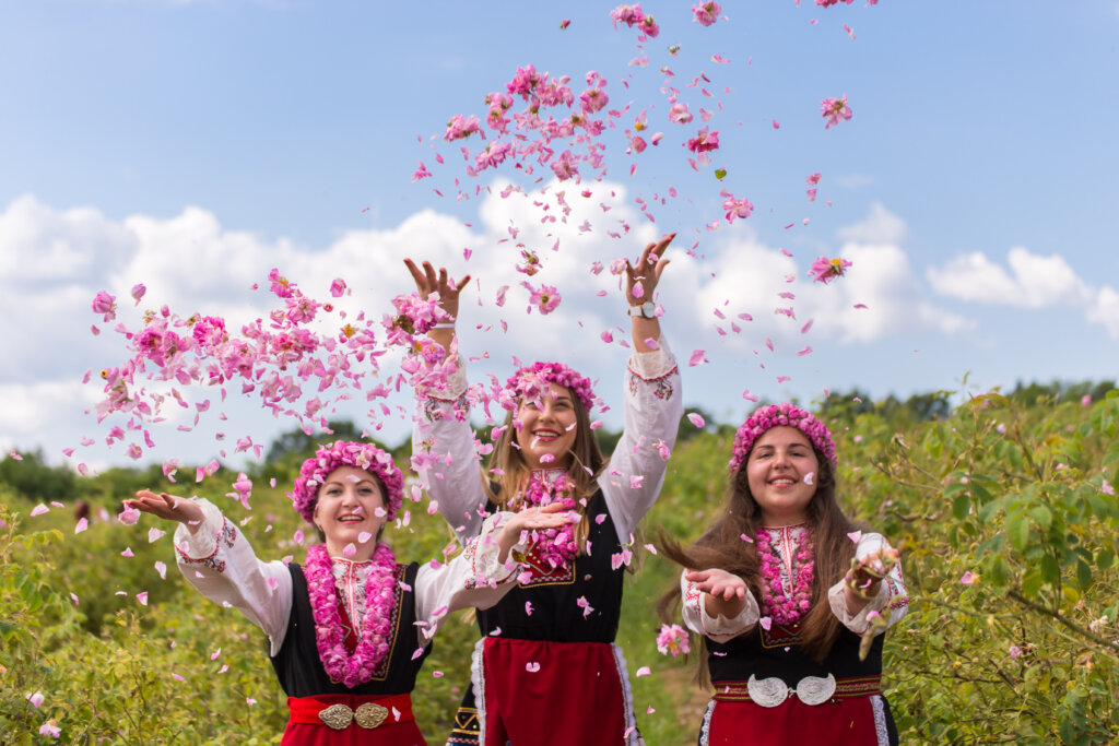 Three,Bulgarian,Girls,Dressed,In,Traditional,Clothing,Throwing,Rose,In