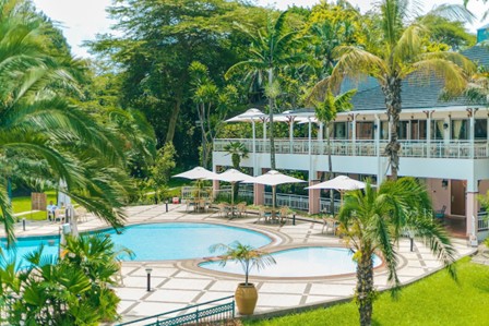 Tropische setting bij Lake Kivu Serena Hotel met zwembad en palmbomen – ontspannen aan het water met Christoffel Travel