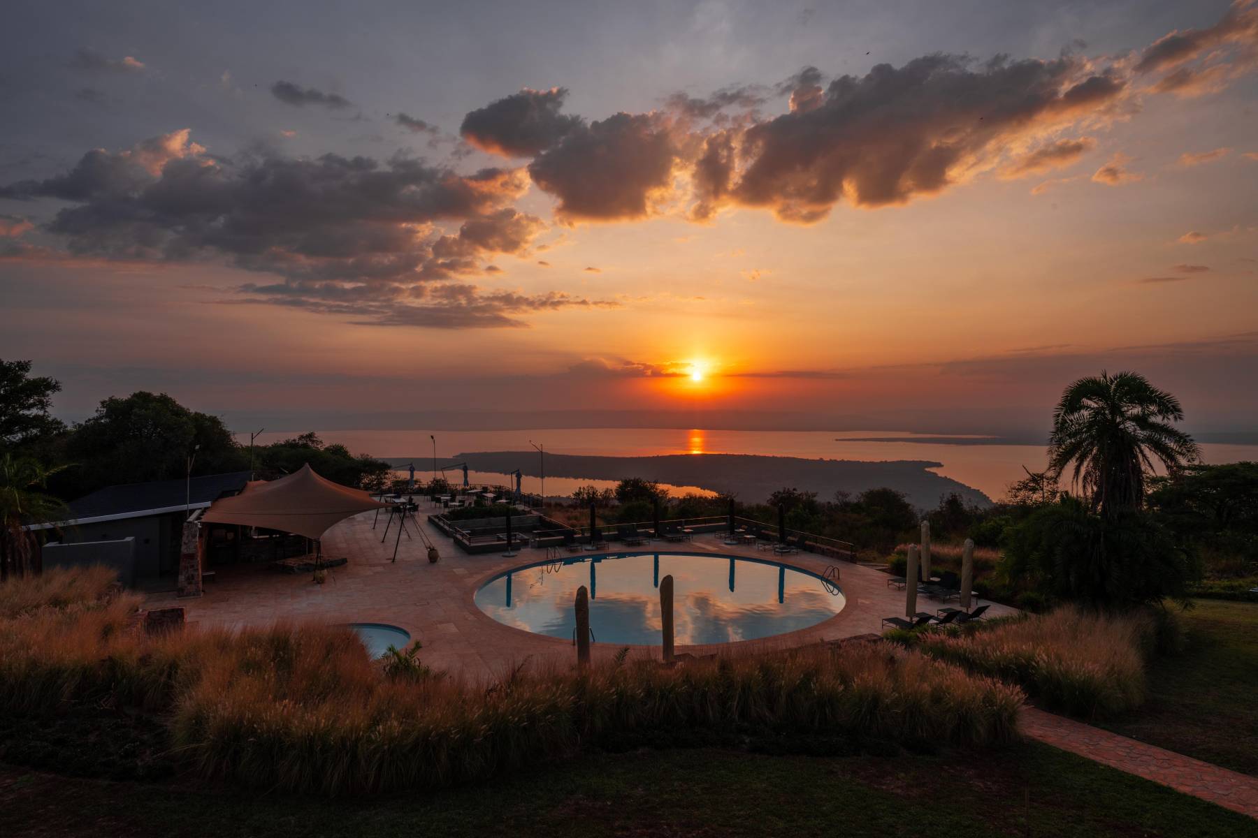 Zonsondergang bij het zwembad van Mantis Akagera Game Lodge met uitzicht over Lake Ihema – safaribeleving met Christoffel Travel