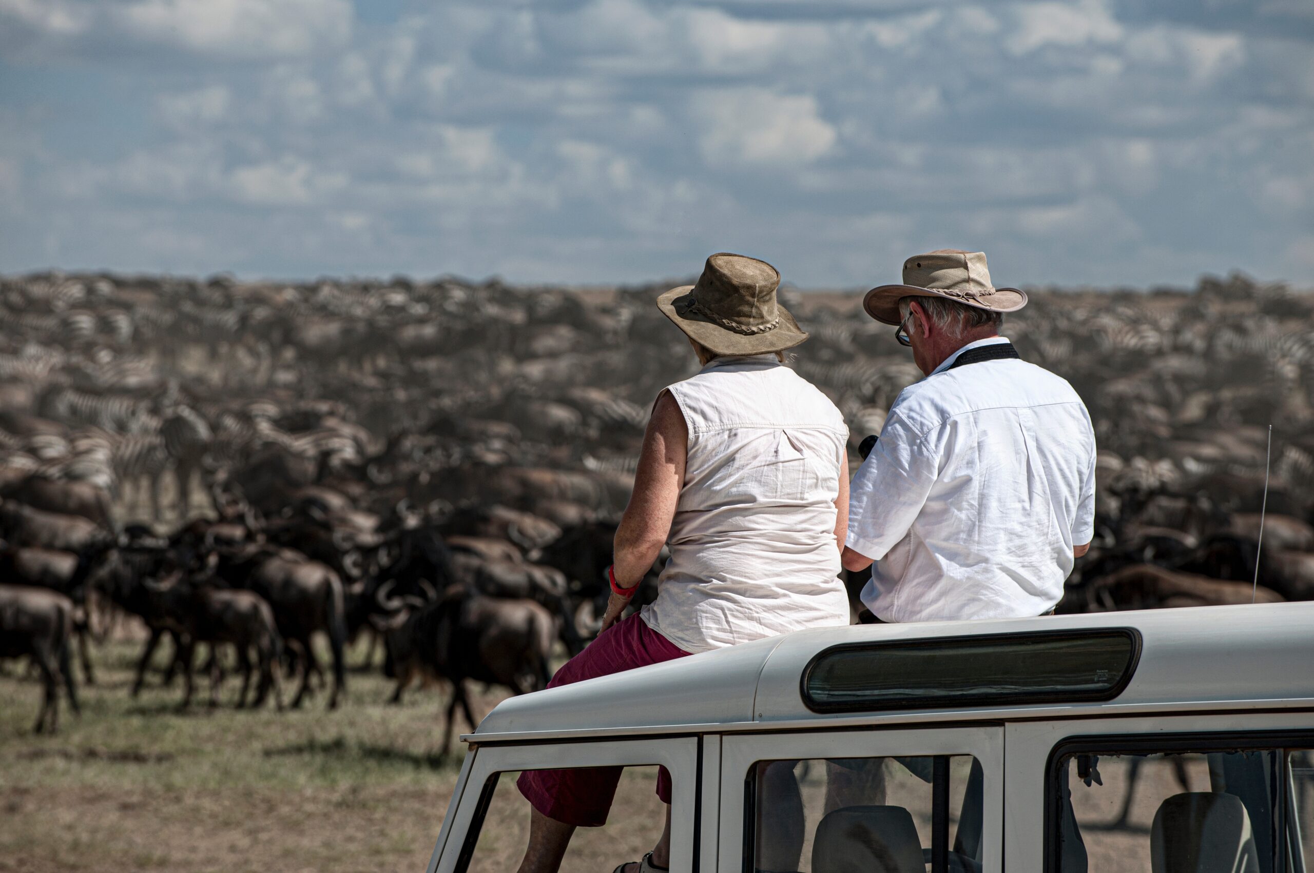 Toeristen op een safarivoertuig tijdens de migratie van gnoes in Serengeti National Park, Tanzania – met Christoffel Travel