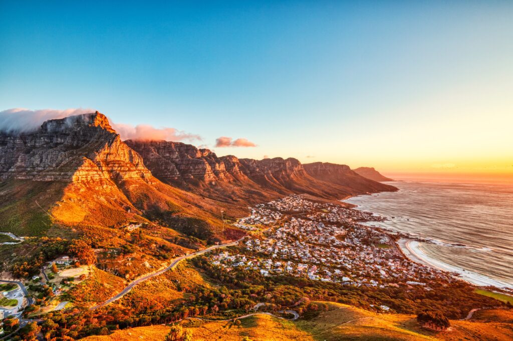 Zonsondergang boven Camps Bay Beach met zicht op de Tafelberg en Twaalf Apostelen – een van de mooiste uitzichten in Kaapstad.