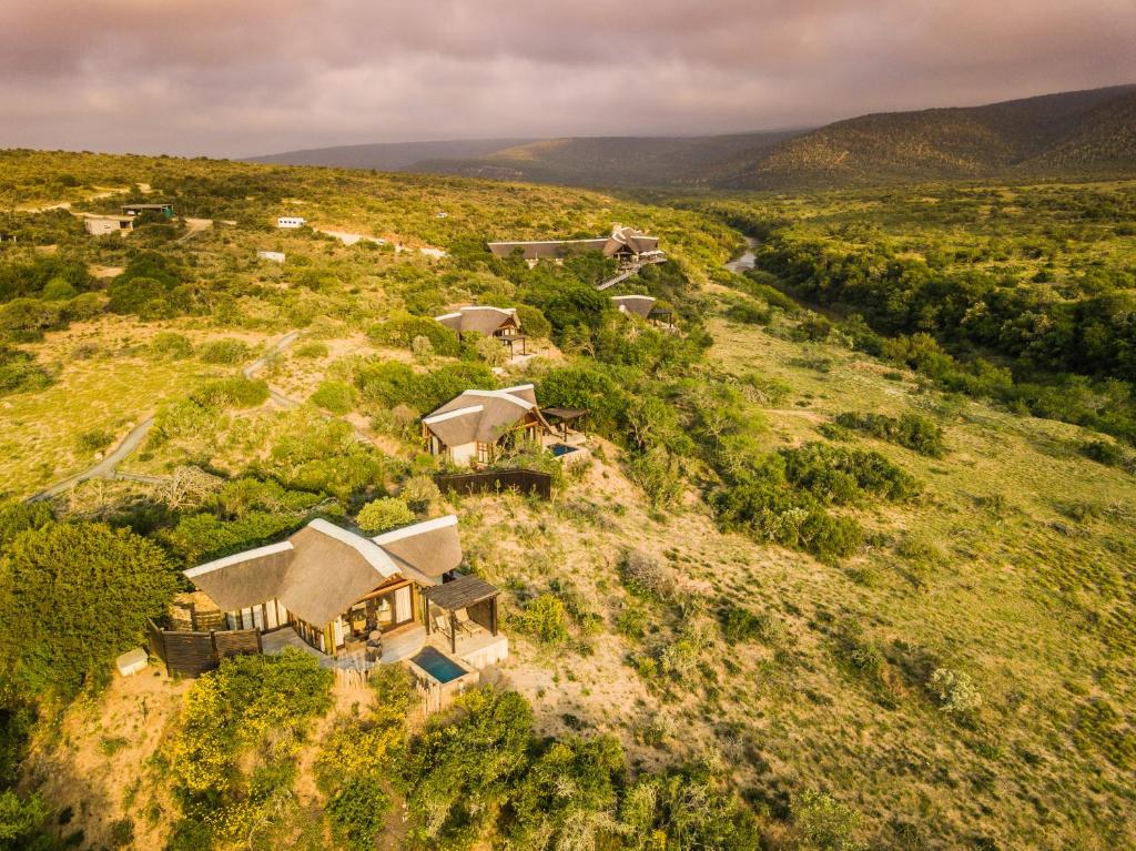 Kwandwe Great Fish River Lodge met uitzicht over savanne en rivier in malaria-vrij reservaat.